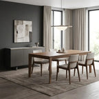 A modern dining room setup featuring a rectangular wooden dining table with six upholstered chairs, set on a textured area rug. The room has dark gray walls, tall windows with beige curtains, and a matching dark gray sideboard with abstract wall art.