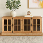 A light natural wood sideboard cabinet with four glass-paneled doors and black metal hinges, styled in a home setting with a potted eucalyptus plant and books on top.
