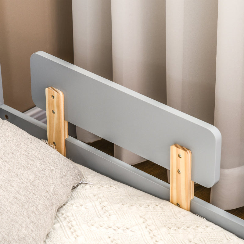 Gray bed rail with wooden supports on a bed against a curtain background