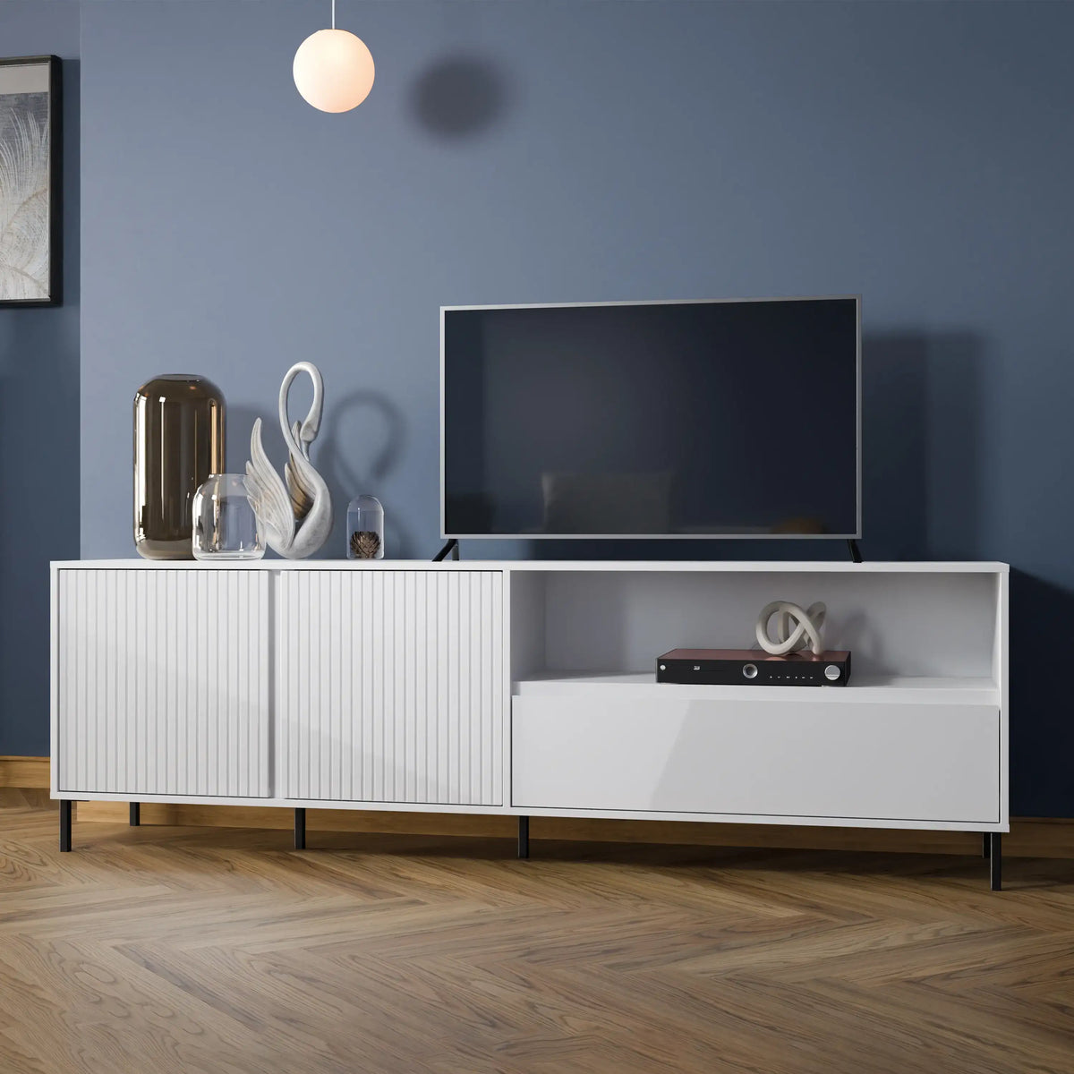 White entertainment console with a TV against a blue wall