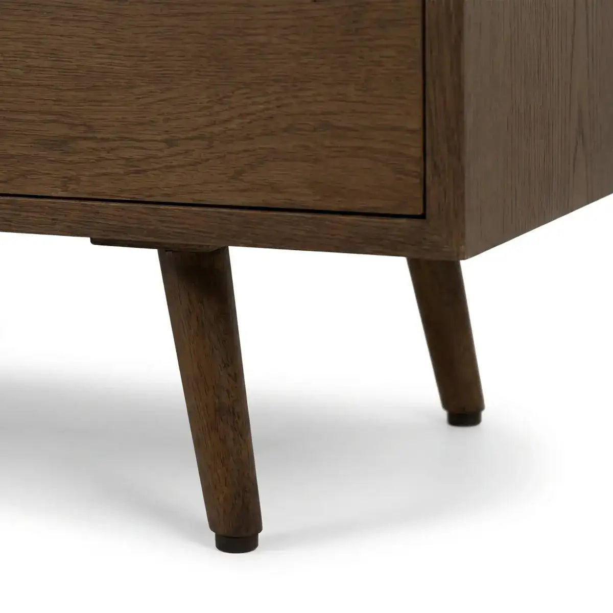 Close-up of a mid-century modern wooden cabinet or sideboard, showing the dark brown wood grain, drawer front, and tapered legs on a white background.