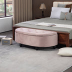 Round beige ottoman in front of a bed in a bedroom setting.