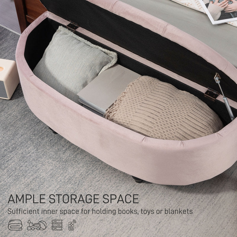 Pink ottoman with storage space containing a pillow and blanket on a gray floor.