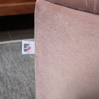 Close-up of a beige fabric surface with a visible brand tag.