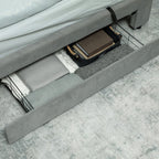 Gray bed frame with a drawer open, revealing a brown bag inside.