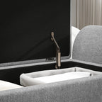 Gray upholstered headboard with a black panel and brass bracket.
