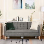 Gray sofa in a living room with decorative pillows and framed pictures on the wall.