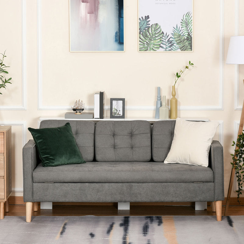Gray sofa in a living room with decorative pillows and framed pictures on the wall.