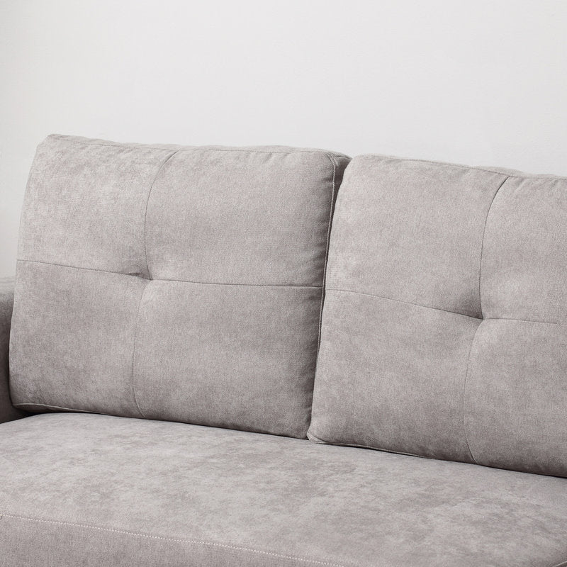 Gray sofa with tufted backrest on a white background