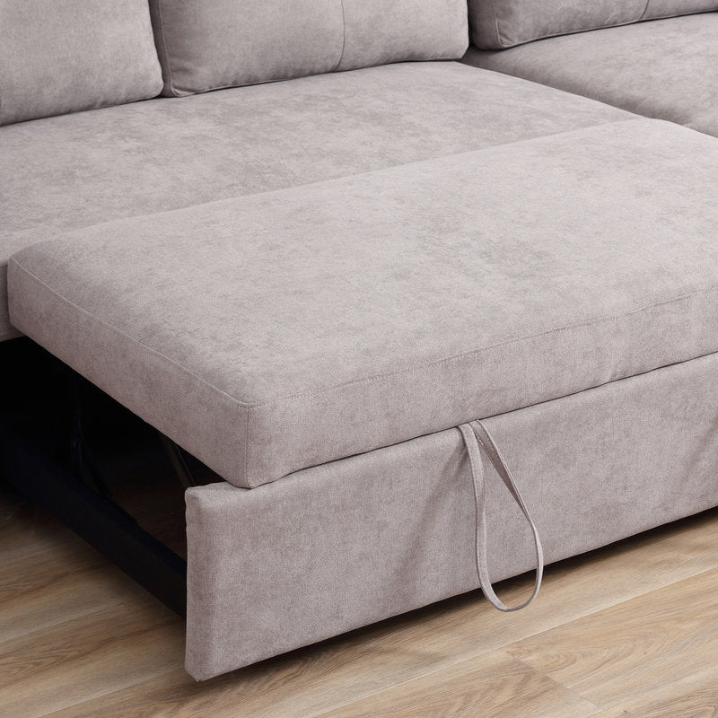 Gray sectional sofa with a pull-out bed mechanism on a wooden floor.