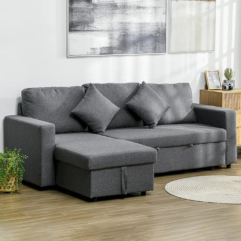 Gray sectional sofa in a living room with a painting on the wall.