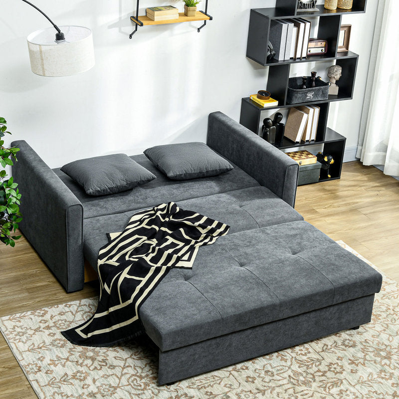 Gray sectional sofa with a patterned blanket in a living room setting.