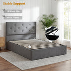 Gray upholstered bed with metal frame and wood slats in a room setting.