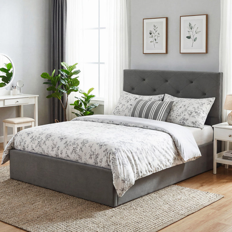 Gray upholstered bed with floral bedding in a well-lit bedroom.