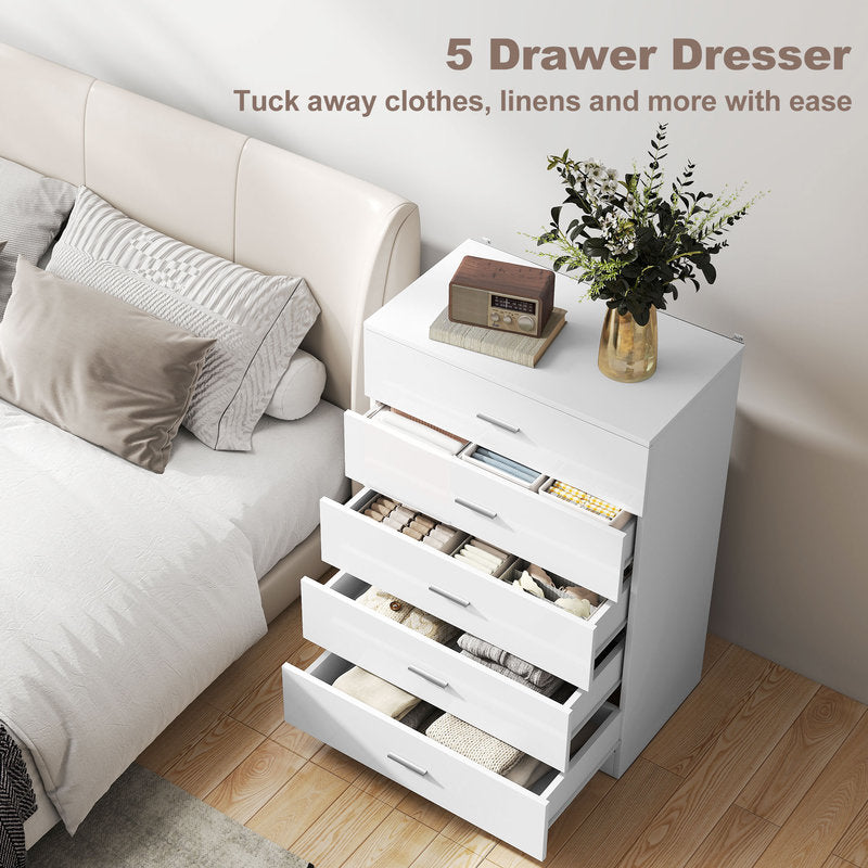 White 5-drawer dresser in a bedroom setting with a sofa and decorative items.