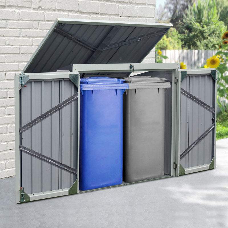 Outdoor trash bin storage unit with two bins, one blue and one gray, against a brick wall.