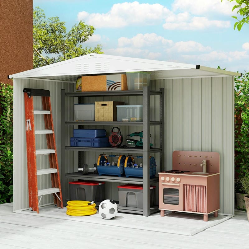 Outdoor storage shed with shelves and a ladder, containing various items including a toy kitchen set.
