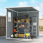 Gray storage shed with various items on shelves against a blue sky.