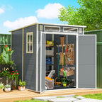 Gray garden shed with open door showing tools and plants, set against a blue sky.