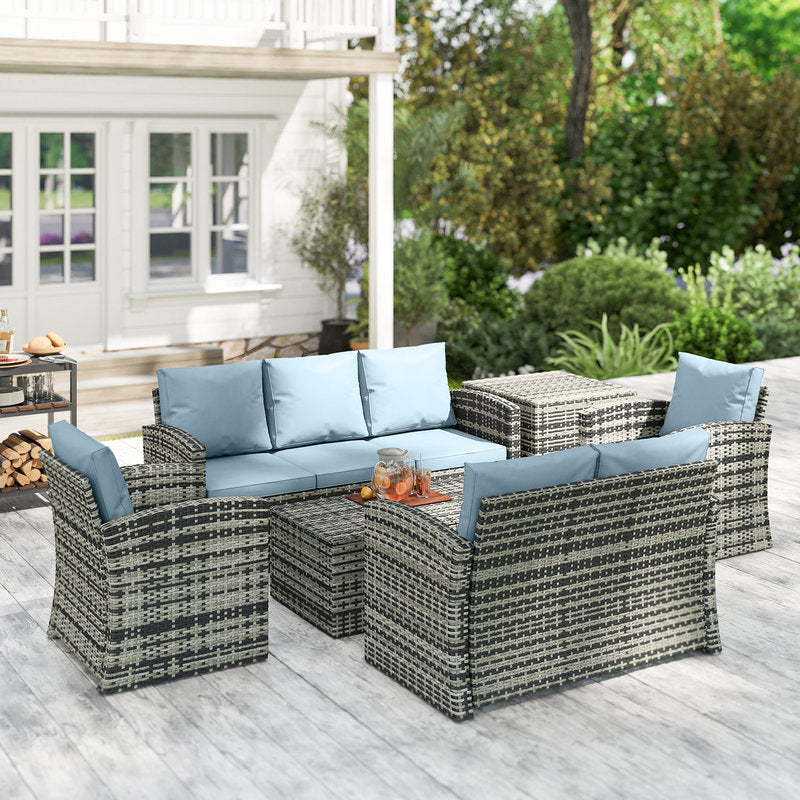Outdoor patio furniture set with wicker chairs and table on a wooden deck.
