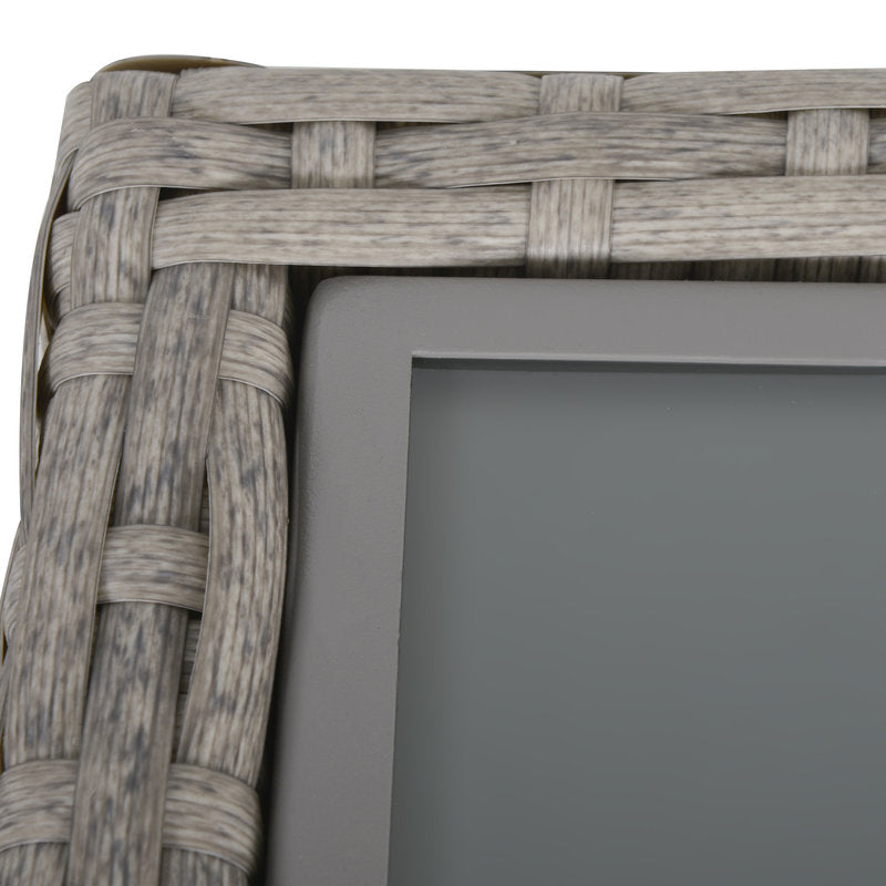 Woven rattan photo frame corner with a plain gray background