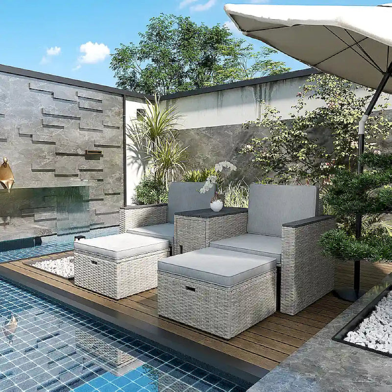 Outdoor patio furniture set by a pool with a stone wall and plants.