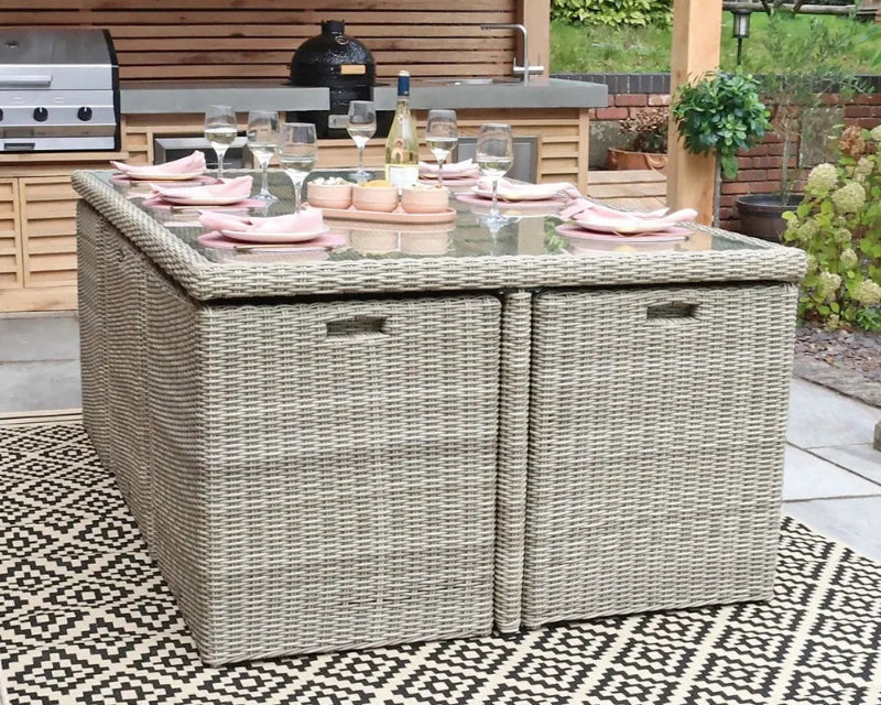 Royalcraft Wentworth cube dining set on patterned rug with garden plants